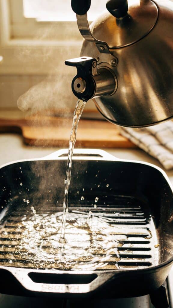 Work in progress photo instruction: kettle pouring water into roasting pan.