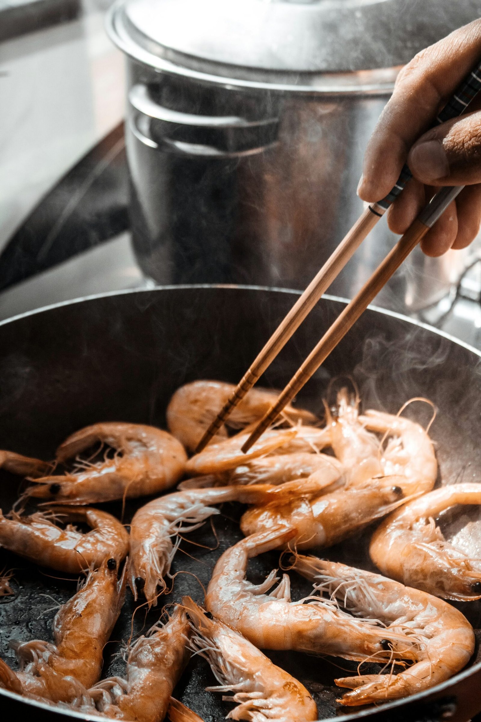 Shrimp cooking in a frying pan, illustrative step photo for keto chili lime shrimp