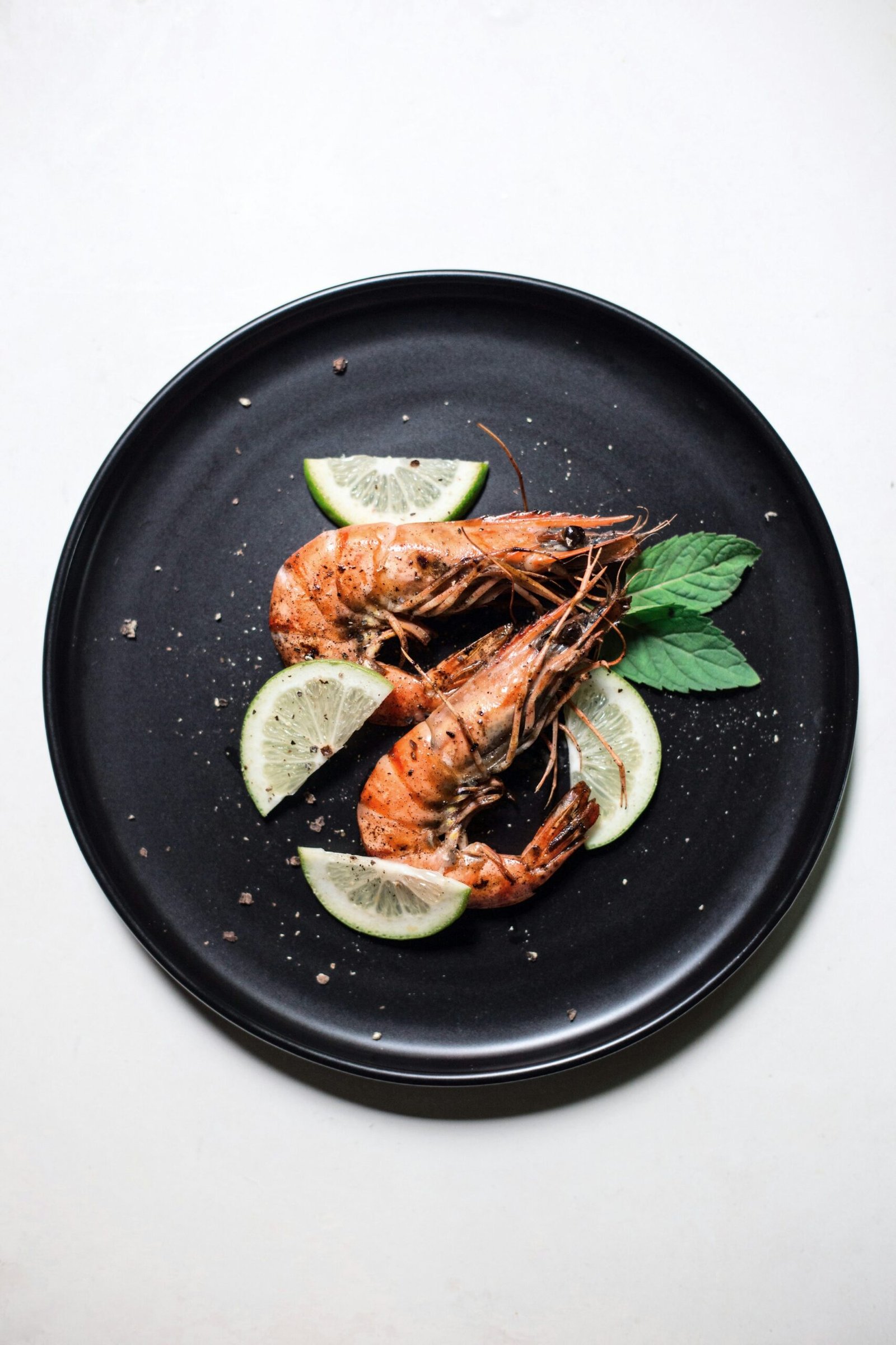 Cooked shrimp served with lime and basil, illustrative serving idea